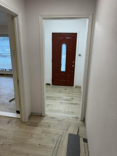 Hallway with new wood flooring and front door